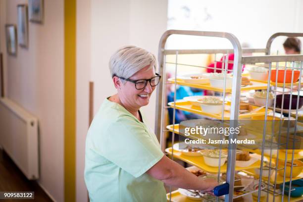 smiling nurse giving food to people - food service occupation bildbanksfoton och bilder