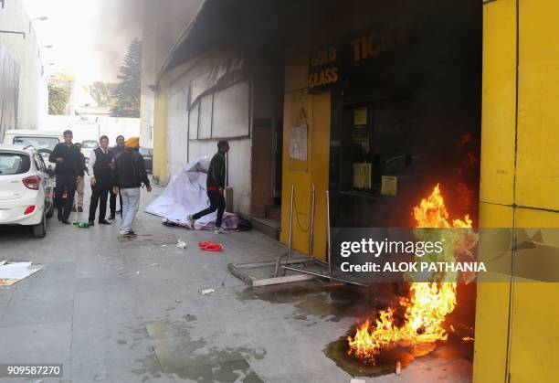 Smoke and fire emerges from a cinema ticket booth after an attack by activists in protest against the Bollywood film 'Padmaavat' in Jammu on January...