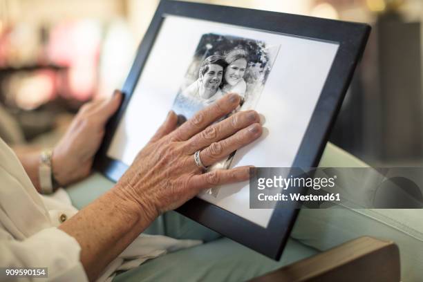 close-up of senior woman holding a photograph - mourning stock-fotos und bilder
