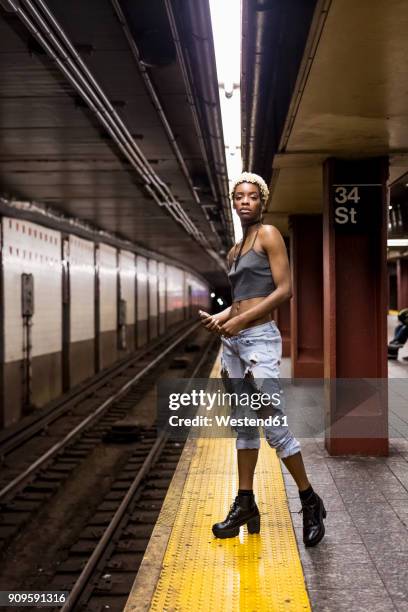 usa, new york city, portrait of woman waiting on subway station platform - metro platform stockfoto's en -beelden