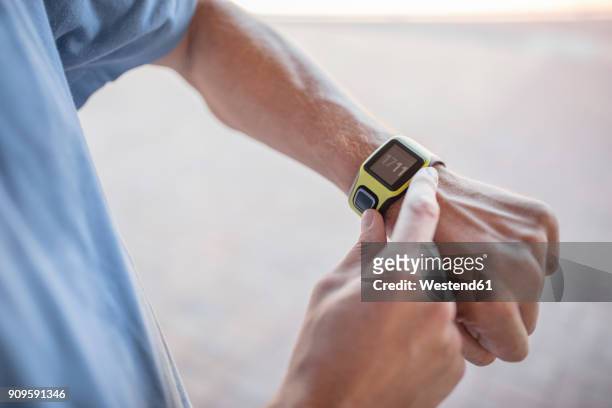 man checking his smartwatch before exercising - arm span stockfoto's en -beelden