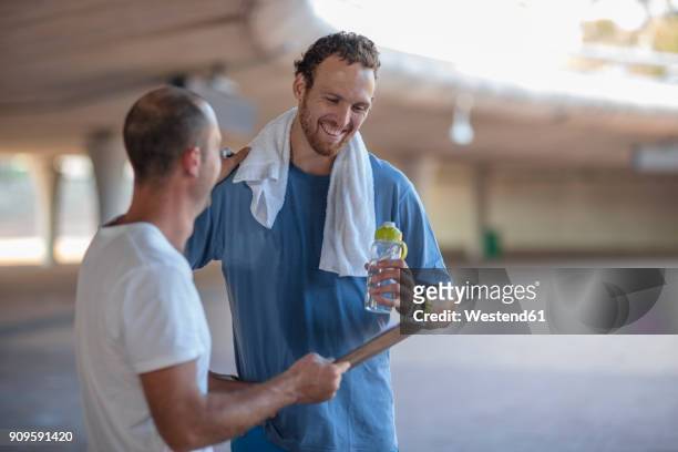 happy sportive man with his fitness coach after exercising - running coach stock pictures, royalty-free photos & images