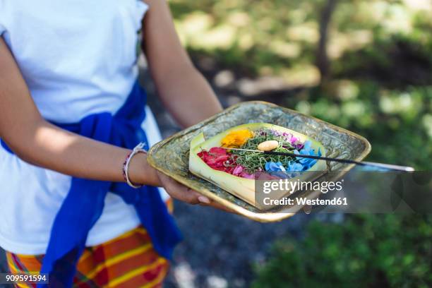 woman holding balinese offering - religiöse opfergabe stock-fotos und bilder