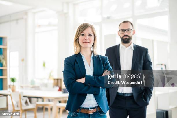 portrait of confident businesswoman and man in office - zwei personen stock-fotos und bilder