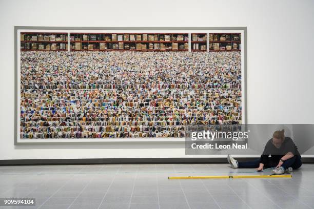 Gallery assistant makes final preparations to a floor marker as she sits in front of "Amazon" by Andreas Gursky in the re-opened Hayward Gallery on...