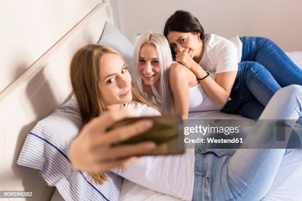 happy female friends taking a selfie in bedroom - bedroom vanity stock pictures, royalty-free photos & images