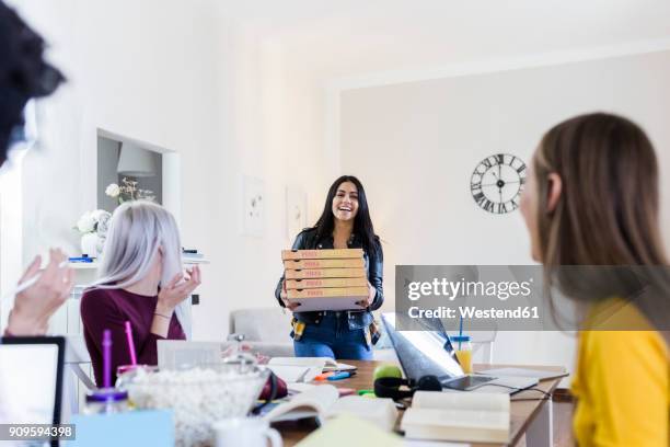 young women bringing pizza for friends studying at home - small business lunch stock pictures, royalty-free photos & images