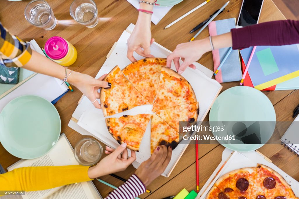 Group of young women at home sharing a pizza