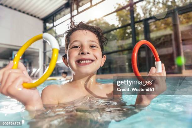 portrait of proud boy holding two diving rings in swimming pool - learning agility stock pictures, royalty-free photos & images