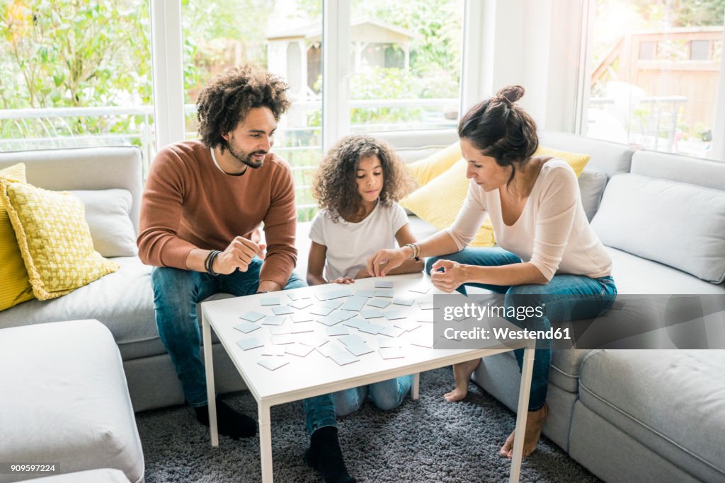 Family sitting on couch , playing memory game