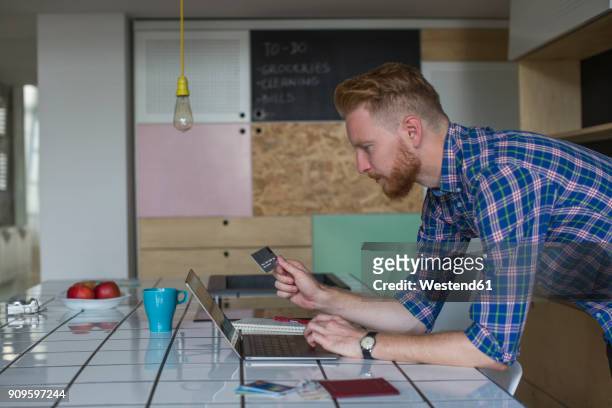 man using credit card and laptop at home - business cards on table stock pictures, royalty-free photos & images