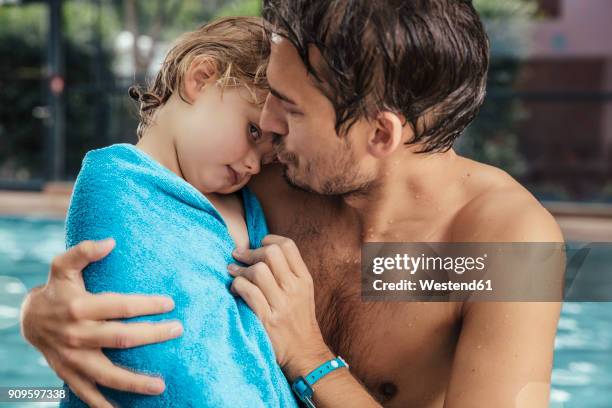 father toweling daughter at the poolside of an indoor swimming pool - kid girl towel stock pictures, royalty-free photos & images