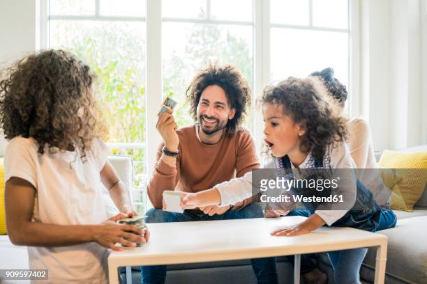 family sitting on couch , playing memory game - game night leisure activity stock pictures, royalty-free photos & images