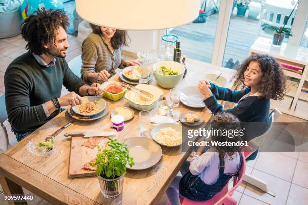 happy family eating together pizza and pasta - family at dining table stock pictures, royalty-free photos & images