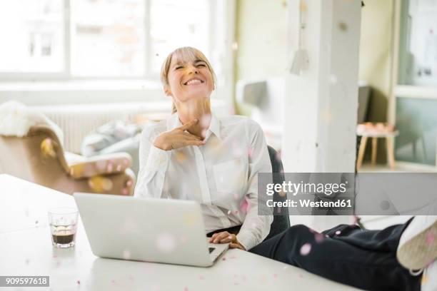 confetti falling on businesswoman with laptop in office - down blouse imagens e fotografias de stock