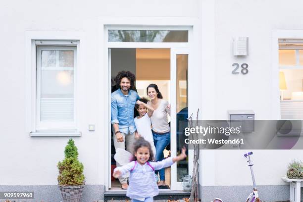 laughing family waiting at the entrance of their home - reihenhaus stock-fotos und bilder