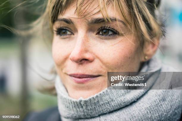 portrait of smiling woman with scarf outdoors - sommersprossen stock-fotos und bilder