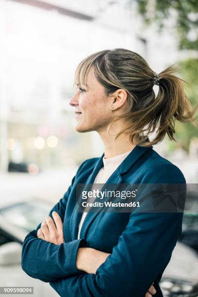 smiling businesswoman in the city - seitenansicht stock-fotos und bilder