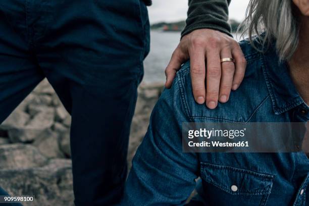 married son putting hand on father's shoulder - responsibility stock-fotos und bilder