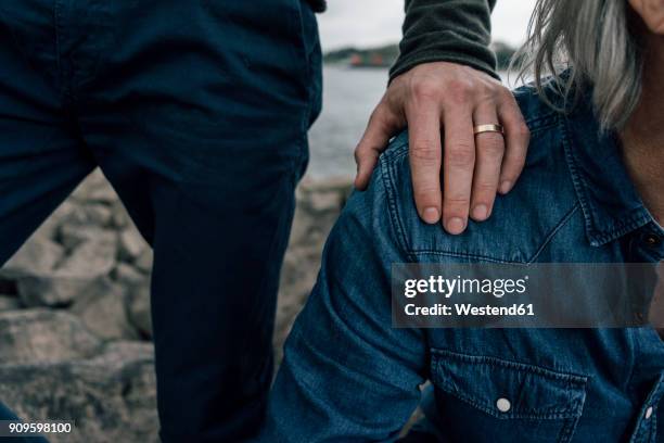 married son putting hand on father's shoulder - men rings foto e immagini stock