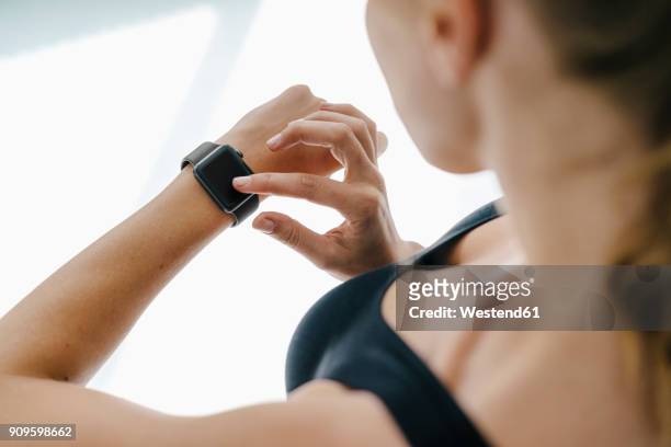 close-up of woman in sportswear adjusting her smartwatch - checking sports stock pictures, royalty-free photos & images