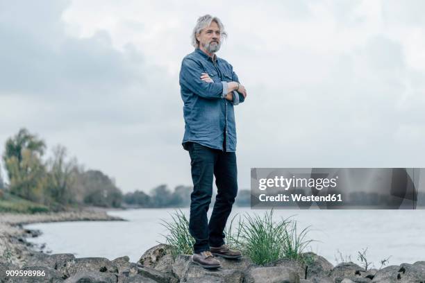 senior man standing on stones looking at rhine river - air escaping stock pictures, royalty-free photos & images