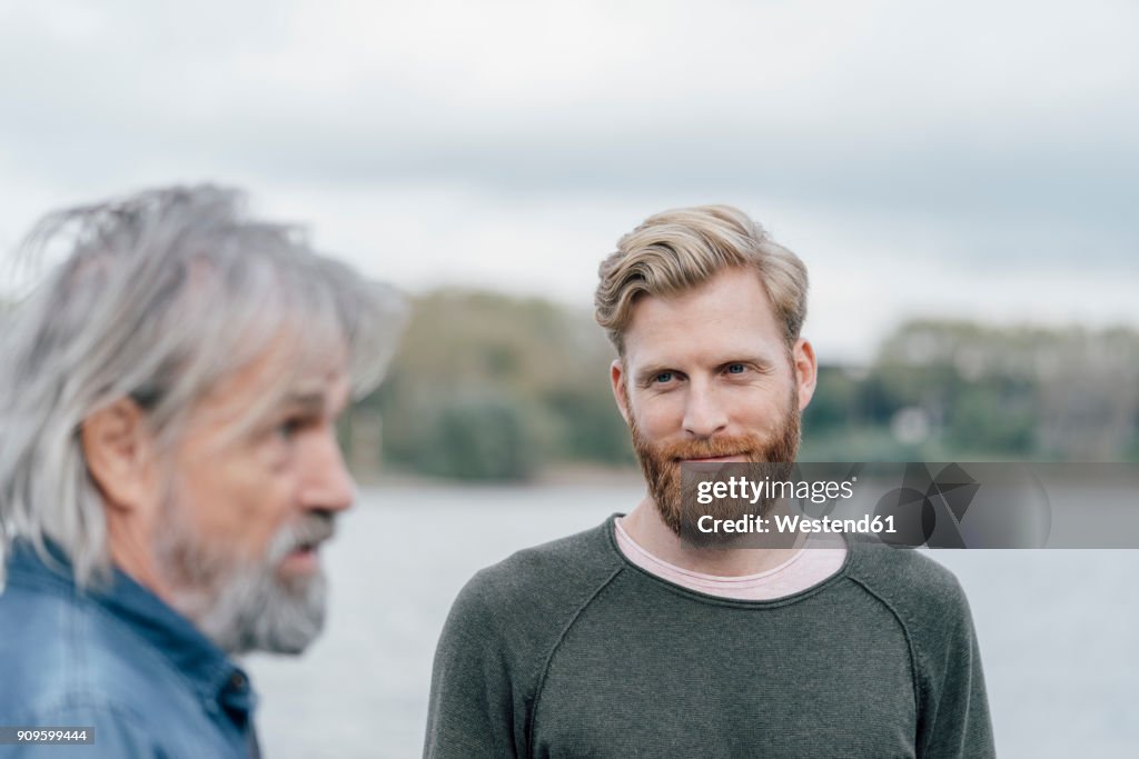 Father and son meeting outdoors, portrait