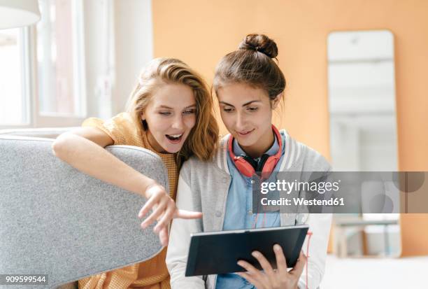 two young women using tablet - surprised woman looking at tablet stock pictures, royalty-free photos & images