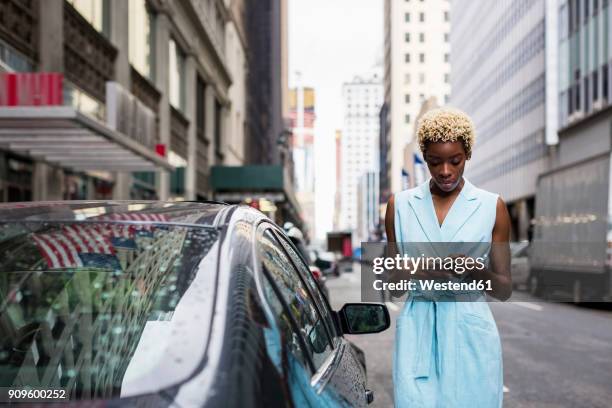 usa, new york, young blonde african-american woman using smartphone - businesswoman nyc stockfoto's en -beelden