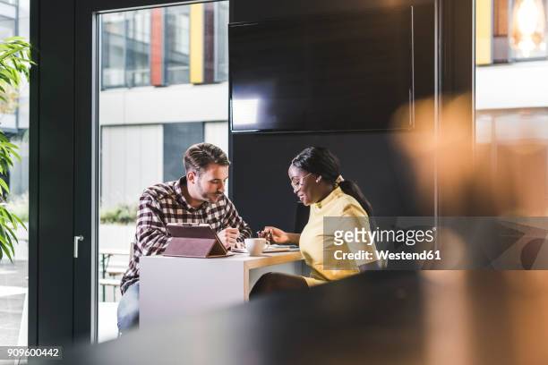 colleagues working together in a cafe - business meeting cafe stock pictures, royalty-free photos & images