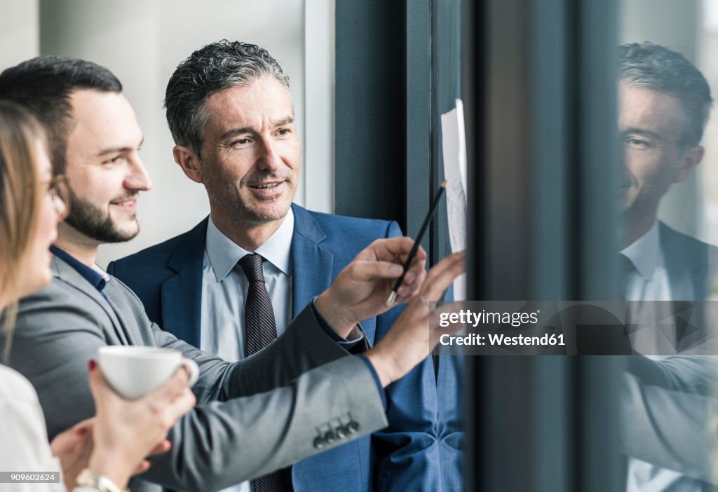 Smiling business people talking in office at the window