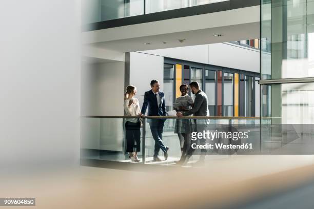 business people talking on office floor - four people stock-fotos und bilder