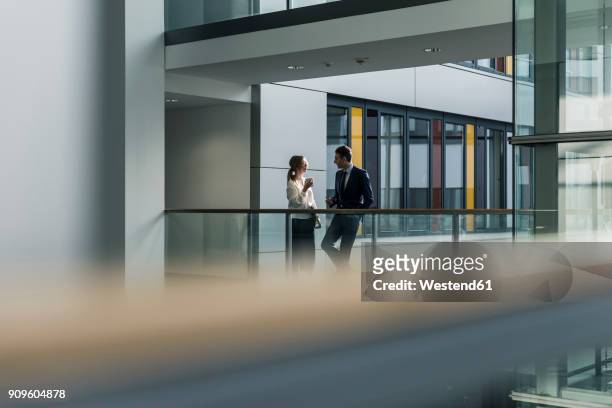 businessman and businesswoman talking on office floor - selective focus stock-fotos und bilder