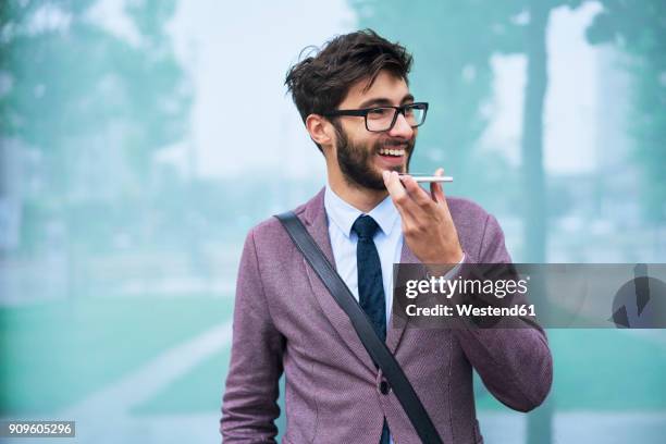 portrait of happy young businessman on the phone outdoors - one kid one world a night of 18 laughs stockfoto's en -beelden