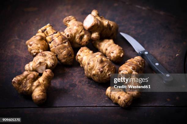 jerusalem artichokes and kitchen knife on rusty ground - jerusalem artichoke stock pictures, royalty-free photos & images