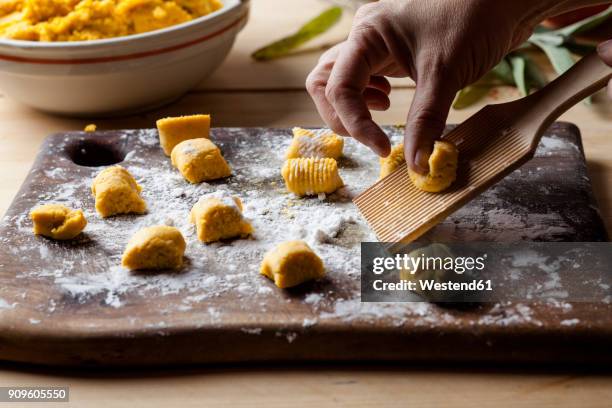 preparing pumpkin gnocchi, rolling on wooden board - gnocchi stockfoto's en -beelden