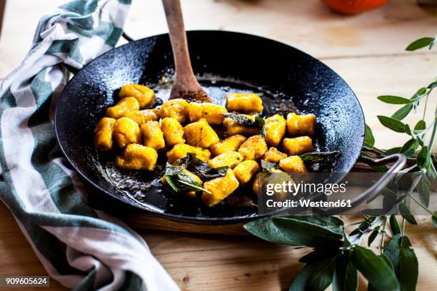 pumpkin gnocchi in frying pan, tossed in sage butter - sage stockfoto's en -beelden