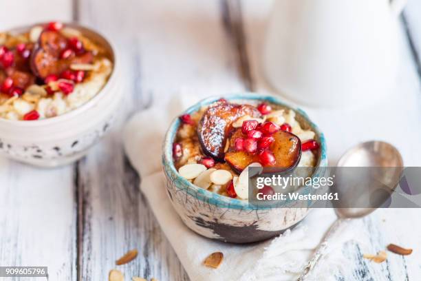 porridge with cinnamon, millet, backed plum, pomegranate and roasted almond slivers - fiocchi di avena foto e immagini stock