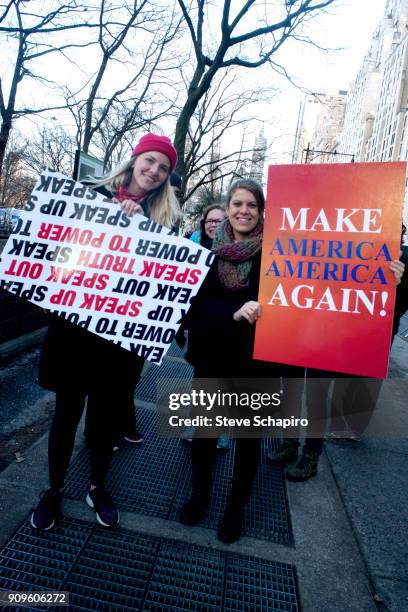View of unidentified demonstrators, both with signs, at the Women's March on New York, New York, January 20, 2018. The women at left holds a sign,...