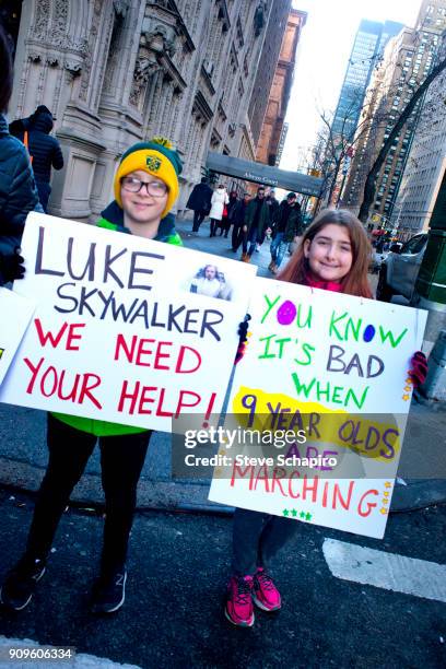 View of unidentified, young demonstrators, both with signs, at the Women's March on New York, New York, January 20, 2018. Their signs reads, from...