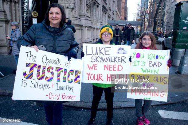 View of an unidentified demonstrator, along with two children, all with signs, at the Women's March on New York, New York, January 20, 2018. Their...
