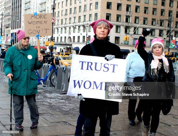 View of unidentified demonstrators, two with signs, at the Women's March on New York, New York, January 20, 2018. Their signs read, from left, 'More...