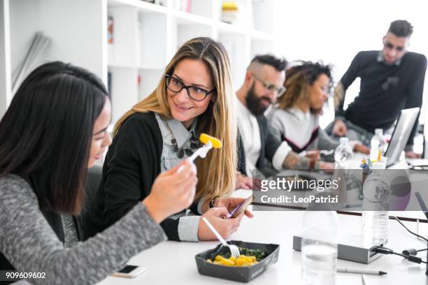 lavorare e pranzare in ufficio - team impegnato - worker lunch foto e immagini stock