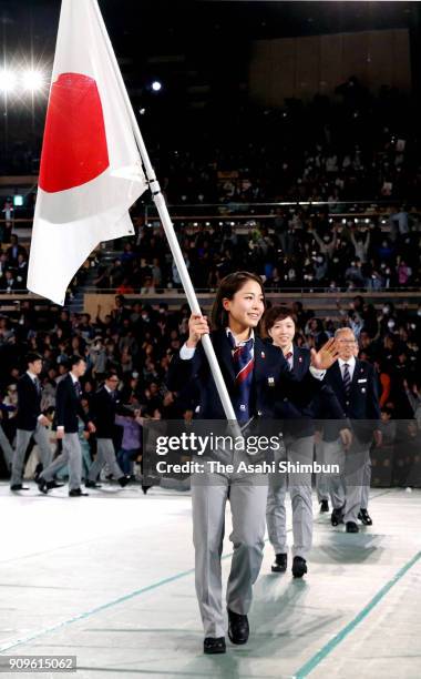 Sara Takanashi bears the national flag during the PyeongChang Winter Olympic Japan Team sending off ceremony at the Ota City General Gymnasium on...