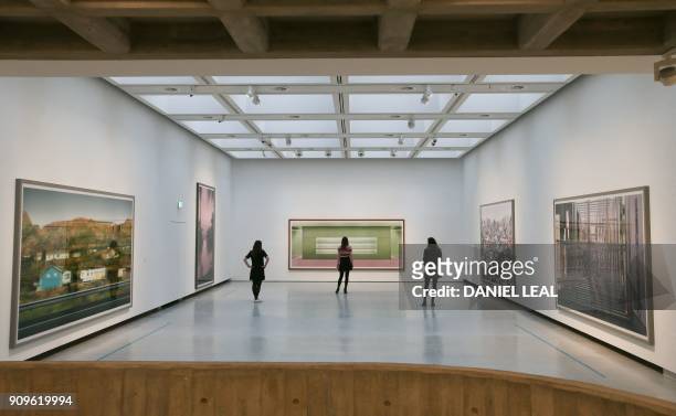 Gallery assistants pose in front of artworks by German photographer Andreas Gursky entitled 'SH, 2013', 'Prada II, 1997' and 'Tokyo, 2017', at the...