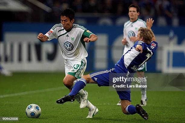 Makoto Hasebe of Wolfsburg is challenged by Lewis Holtby of Schalke during the Bundesliga match between FC Schalke 04 and VfL Wolfsburg at Veltins...