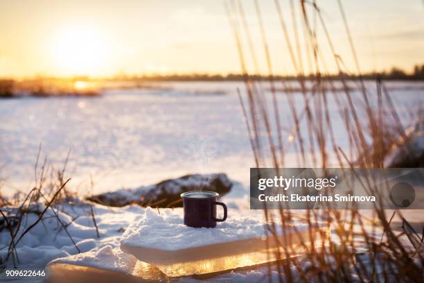 cup of hot coffee on snow, winter sunny day background - hot drink stock pictures, royalty-free photos & images