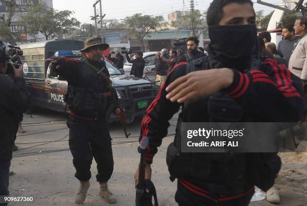 Pakistani policemen escort the police van carrying a suspect accused of raping and murdering a young girl as they arrive at an anti-terrorist court...