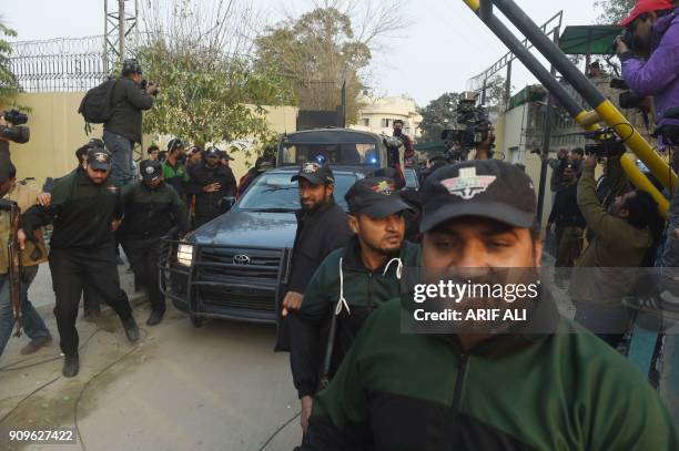Pakistani policemen escort the police van carrying a suspect accused of raping and murdering a young girl as they leave an anti-terrorist court in...