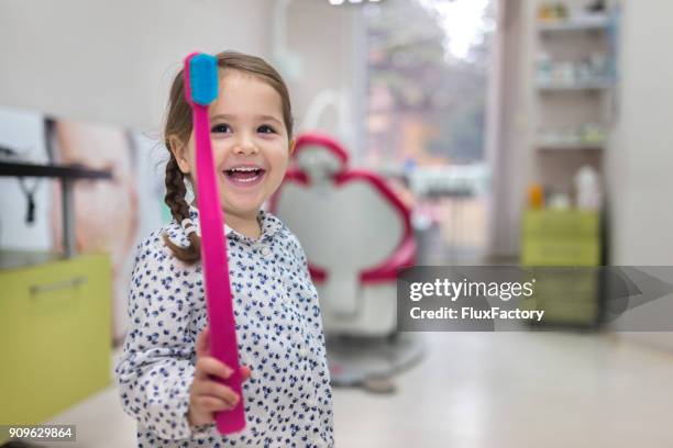 das spiel mit einer großen zahnbürste - pediatric dentistry stock-fotos und bilder